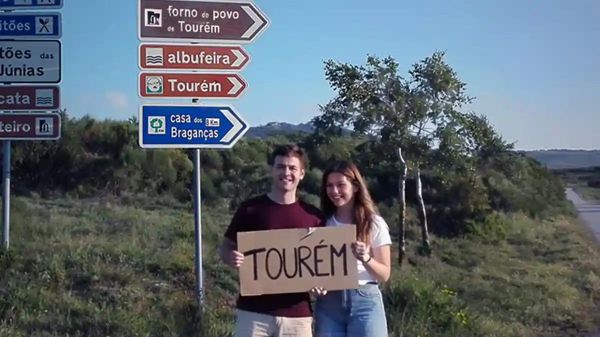 Placas de sinalização turística para Tourém e Espanha com jovens a segurar cartaz