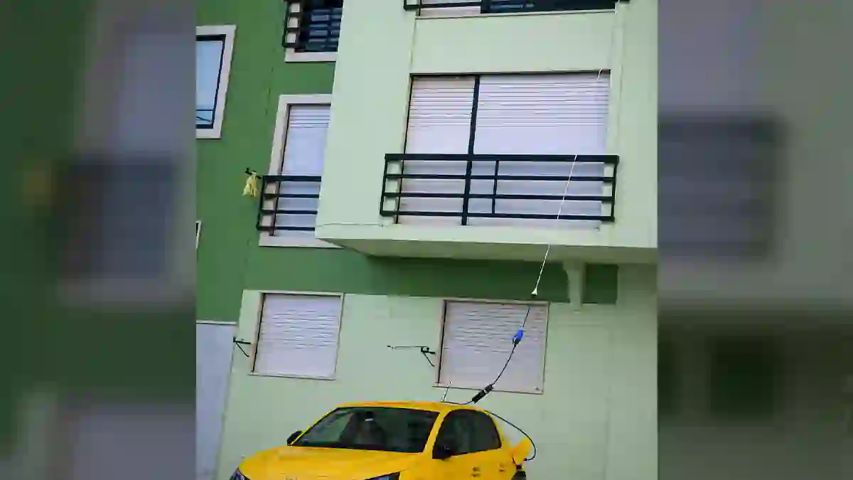 Automóvel elétrico a carregar através de um cabo de alimentação ligado a uma infraestrutura doméstica